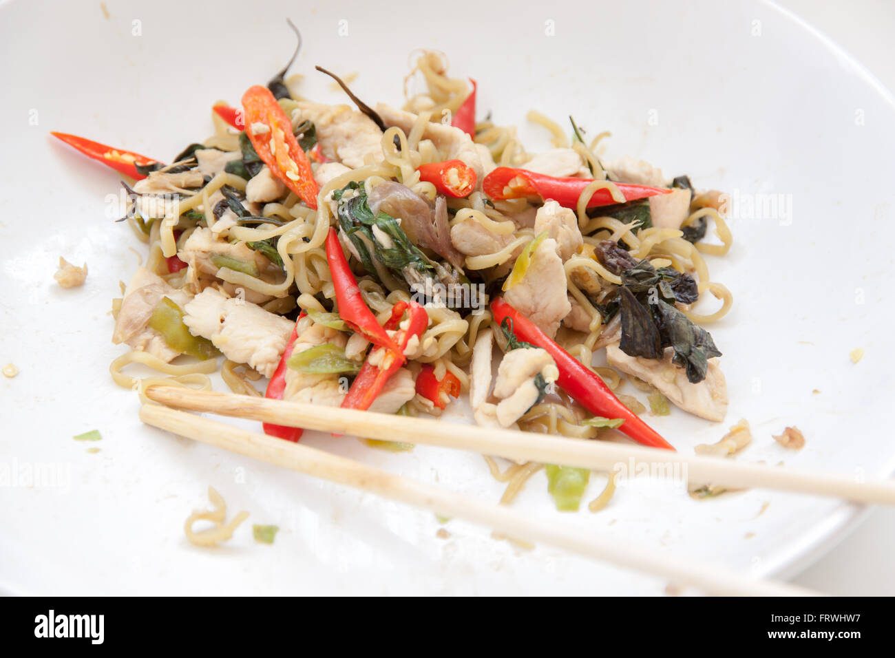 Chinesische Nudeln mit Huhn in weiße Platte gebraten. Stockfoto