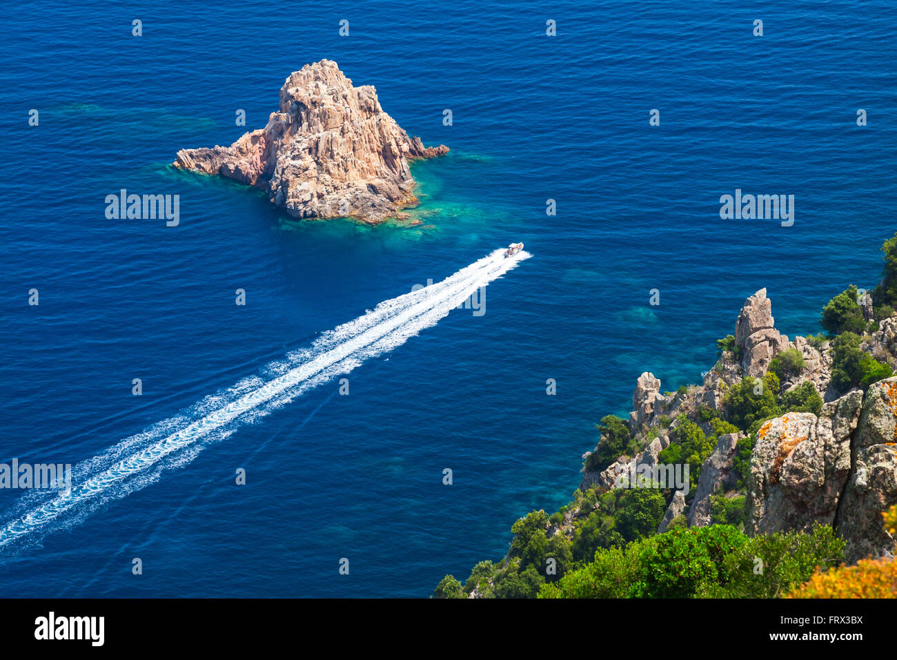 Schnell Motorboot geht zwischen den Steinen des Capo Rosso, Piana Region, Süd-Korsika, Frankreich Stockfoto