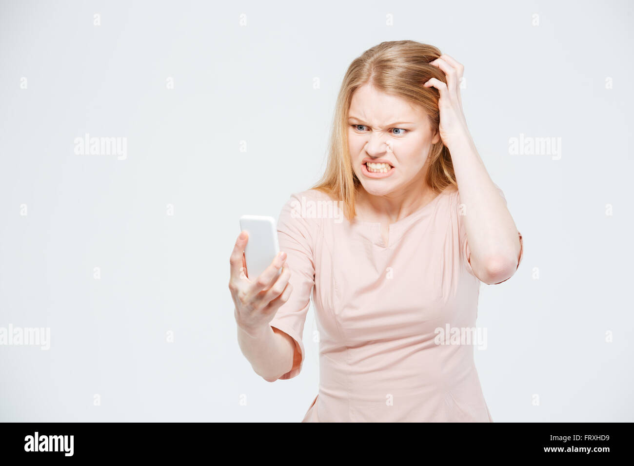 Böse Frau mit Smartphone isoliert auf weißem Hintergrund Stockfoto