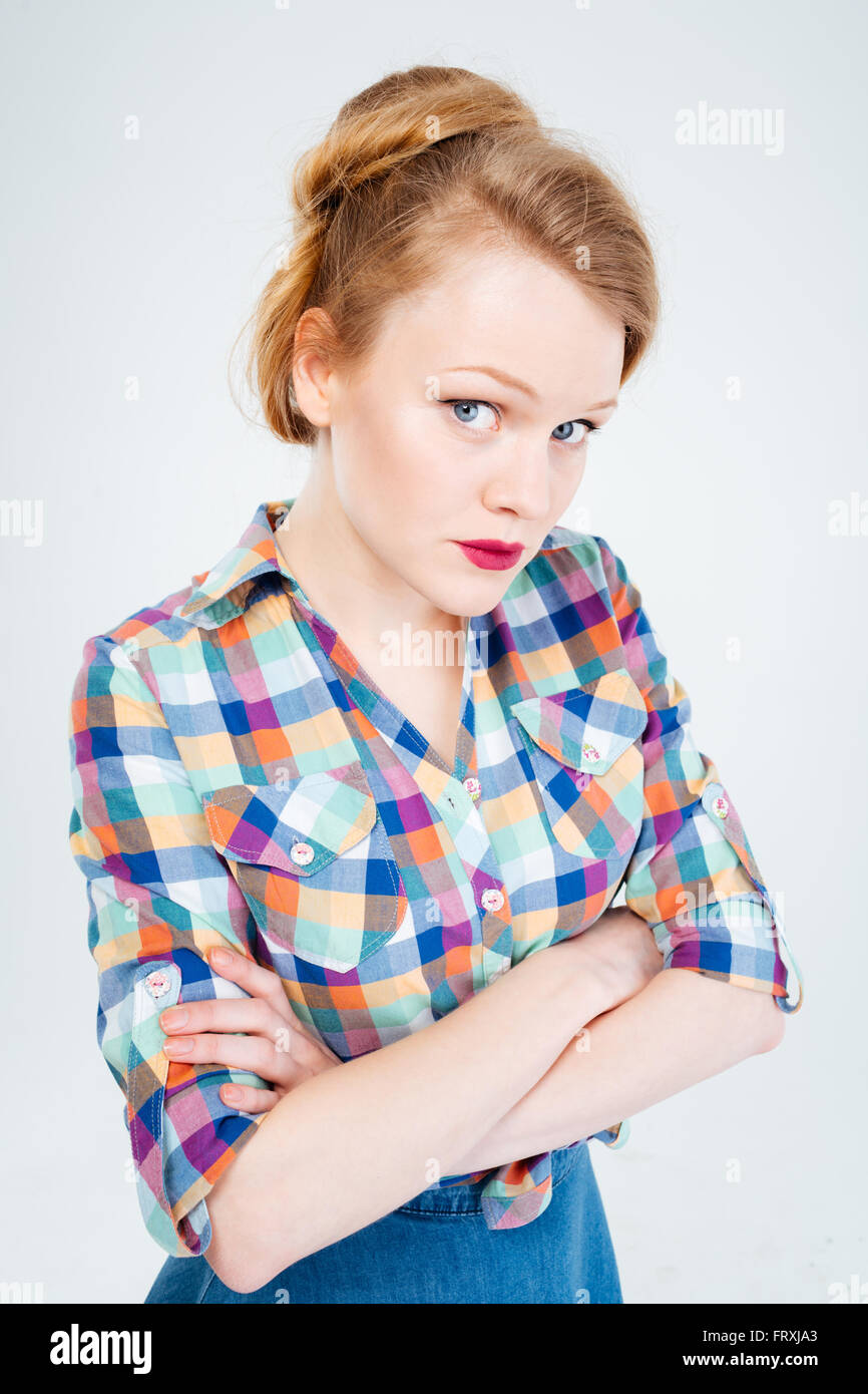 Wütende Frau stand mit verschränkten Armen auf einem weißen Hintergrund isoliert Stockfoto