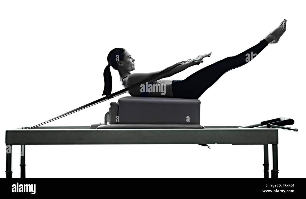 eine Kaukasische Frau Ausübung Pilates Reformer Übungen Fitness Silhouette isoliert auf weißem Hintergrund Stockfoto