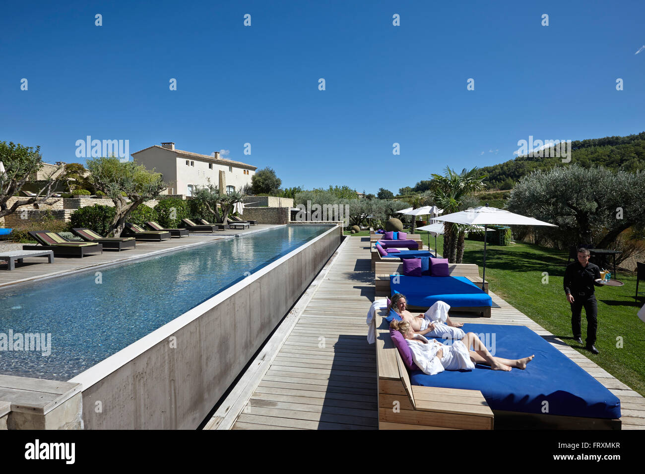 Gäste entspannen Sie sich auf Liegestühlen am Hotelpool, Saint-Saturnin-Les-Apt, Provence, Frankreich Stockfoto
