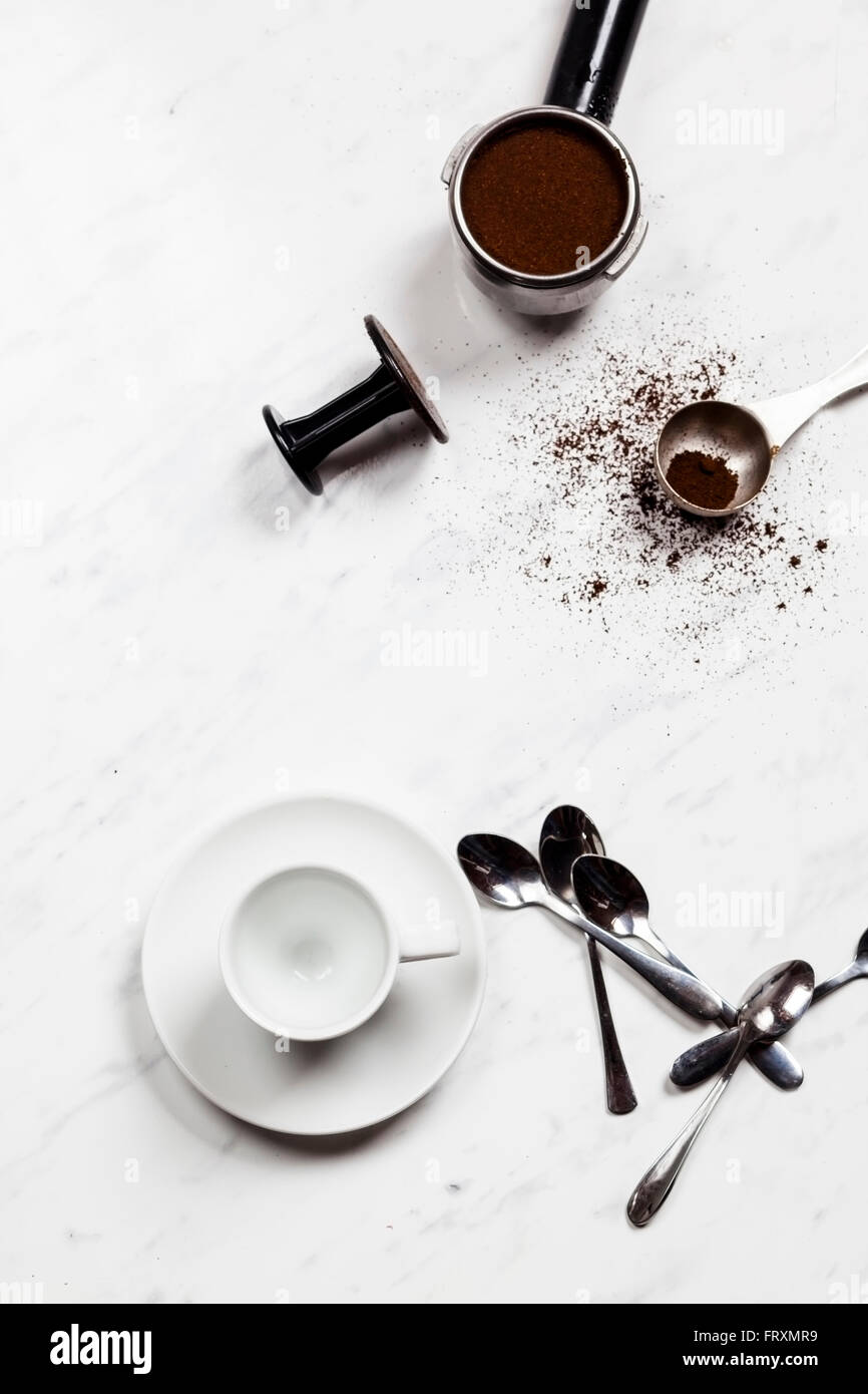 Leere Espressotasse, Löffel und unter Druck stehenden Portafilter auf weißem Marmor Stockfoto