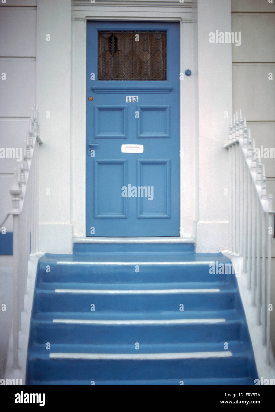 Blau lackierten Schritte bis zur blauen Eingangstür eines weißen Stadthauses Stockfoto