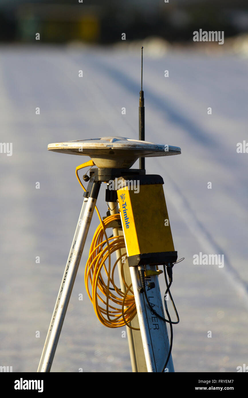 Externer GPS-Empfänger im Burscough, Lancashire, Großbritannien, 25. März 2016 verwendet. UK Wetter. Eine Landschaft, die in weißem Vlies abgedeckt, da die Landwirte Trimble GPS-Traktor-Leitsysteme Ausrüstung verwenden, um ihre Felder zu Handlung und Werk und salatpflänzlinge dieser Jahreszeiten'. Gartenbau Fleece ist ein dünnes, Ungewebte, Polypropylen Gewebe, das wie eine schwebende Mulch sowohl frühe und späte Ernte und andere empfindliche Pflanzen vor Kälte und Frost, sowie Insekten während der normalen Vegetationsperiode zu schützen, verwendet wird. Stockfoto