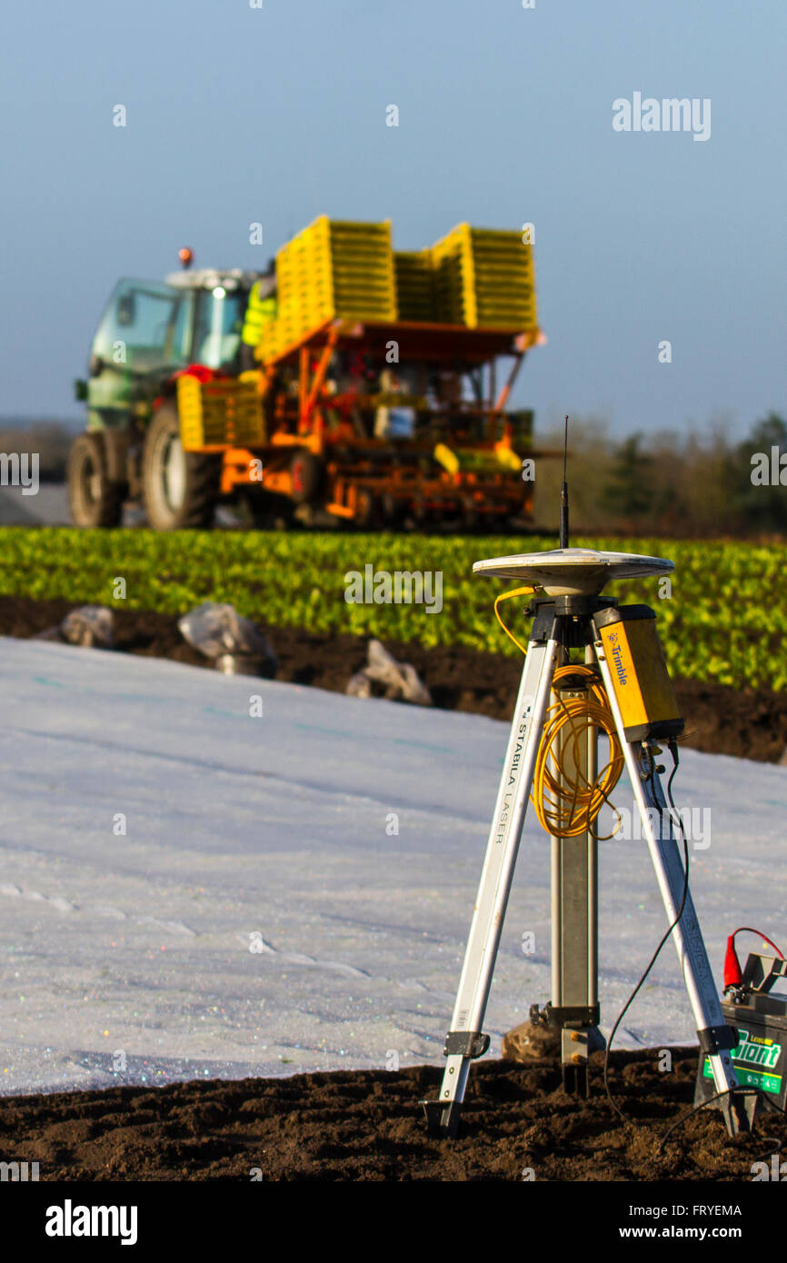 Externer GPS-Empfänger im Burscough, Lancashire, Großbritannien, 25. März 2016 verwendet. UK Wetter. Eine Landschaft, die in weißem Vlies abgedeckt, da die Landwirte Trimble GPS-Traktor-Leitsysteme Ausrüstung verwenden, um ihre Felder zu Handlung und Werk und salatpflänzlinge dieser Jahreszeiten'. Gartenbau Fleece ist ein dünnes, Ungewebte, Polypropylen Gewebe, das wie eine schwebende Mulch sowohl frühe und späte Ernte und andere empfindliche Pflanzen vor Kälte und Frost, sowie Insekten während der normalen Vegetationsperiode zu schützen, verwendet wird. Stockfoto