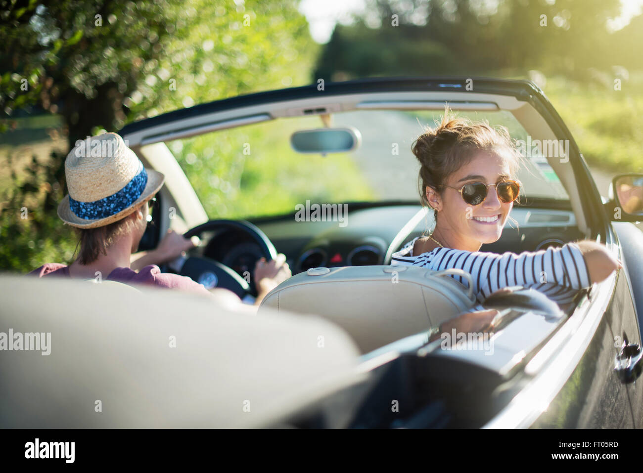 Sicht nach hinten. Junge trendige Paar gerne seine Cabrio fahren auf einer Landstraße im Sommer. Schuss mit Fackel Stockfoto