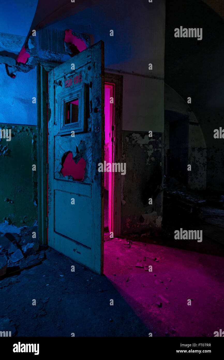 Abstrakte farbige Lichtmalerei in verlassene sowjetische Bunker. Rosa helles Licht durch defekte Türen Stockfoto