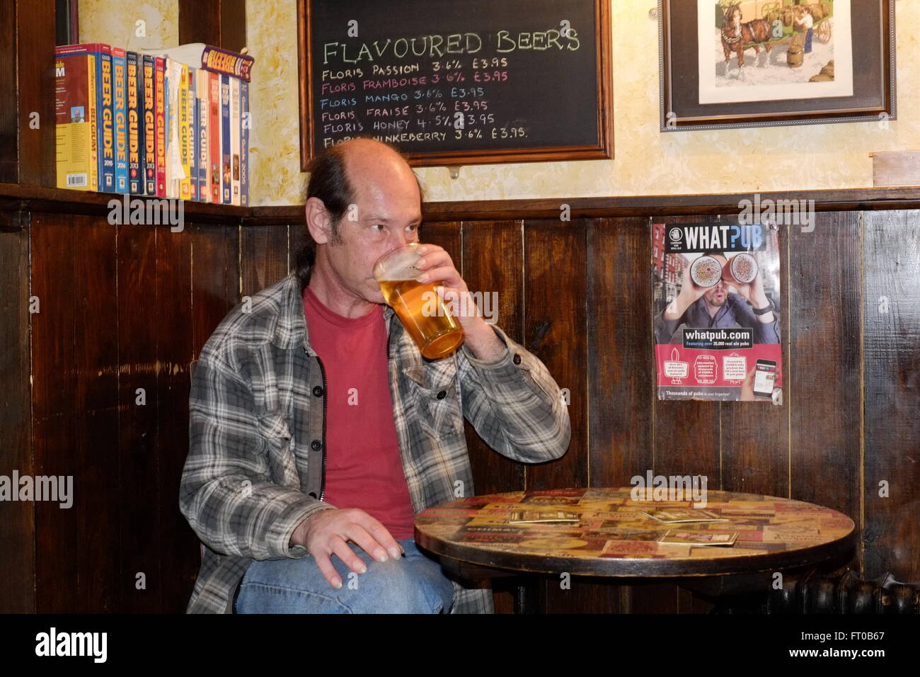 Reifen männlichen trinken einen Pint real Ale im Pub bar das Loch in der Wand Southsea England uk Stockfoto