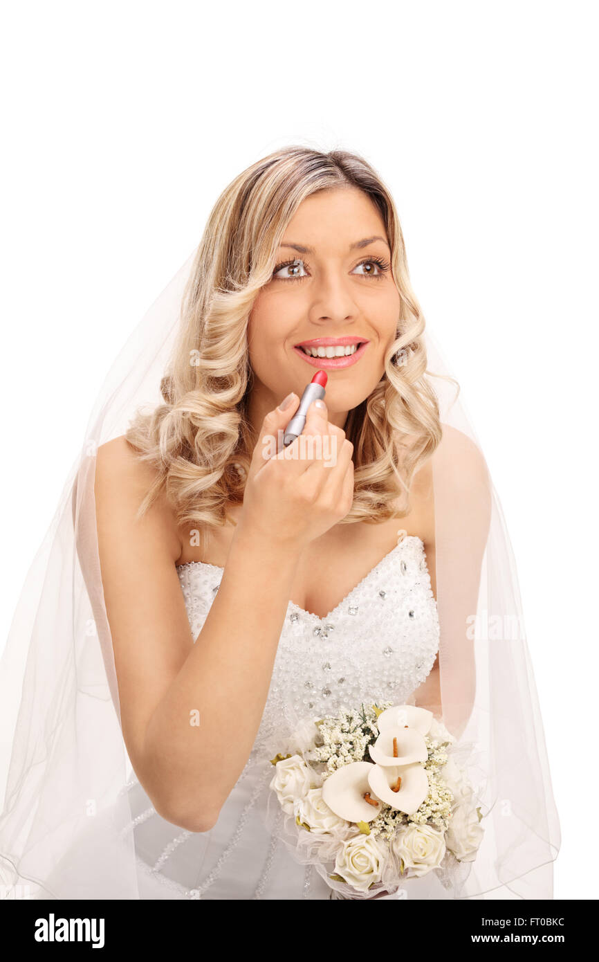 Vertikale Aufnahme einer jungen blonden Braut Auftragen von Lippenstift auf den Lippen und lächelnd isolierten auf weißen Hintergrund Stockfoto