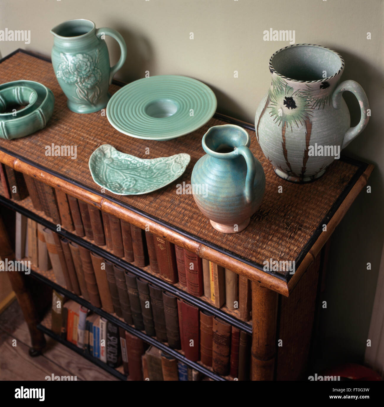 Sammlung von Türkis dreißiger Jahre Keramik auf einem Bambus-Bücherregal Stockfoto