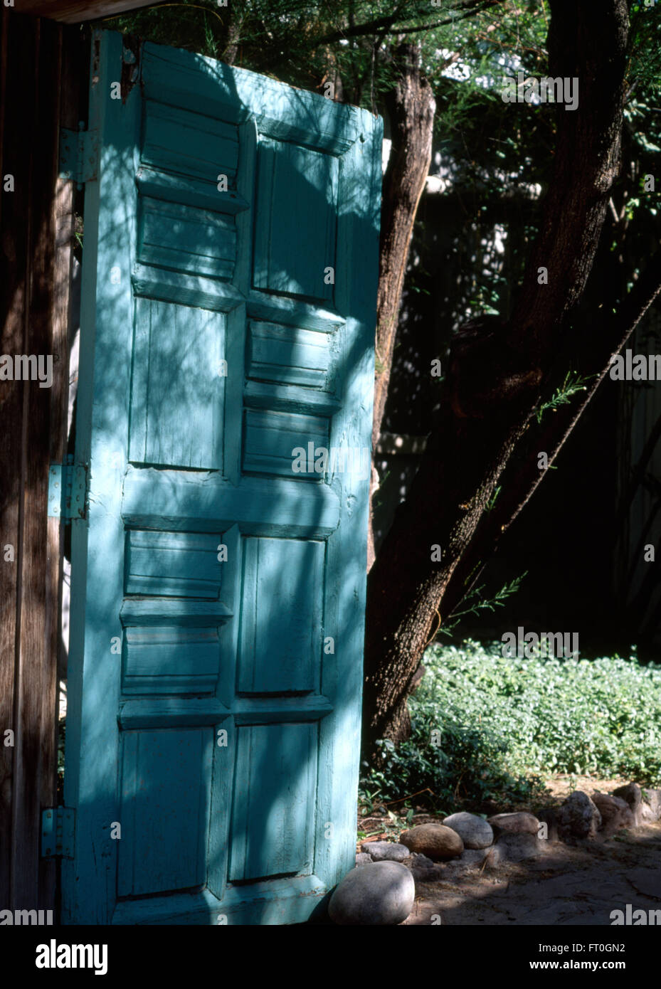 Nahaufnahme von einem blauen Holztor zu einem spanischen Garten Stockfoto