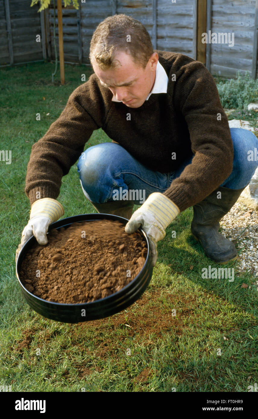 Ein Gärtner Absiebung Kompost vor der Anwendung auf eine neue Grenze für nur zur redaktionellen Nutzung Stockfoto