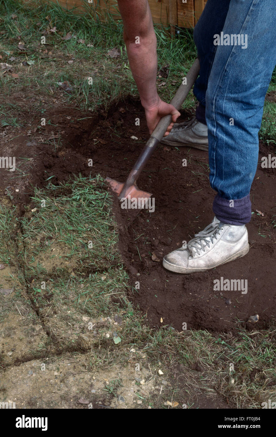 Nahaufnahme eines Gärtners umgraben Rasen vor der Verlegung Pflaster Stockfoto