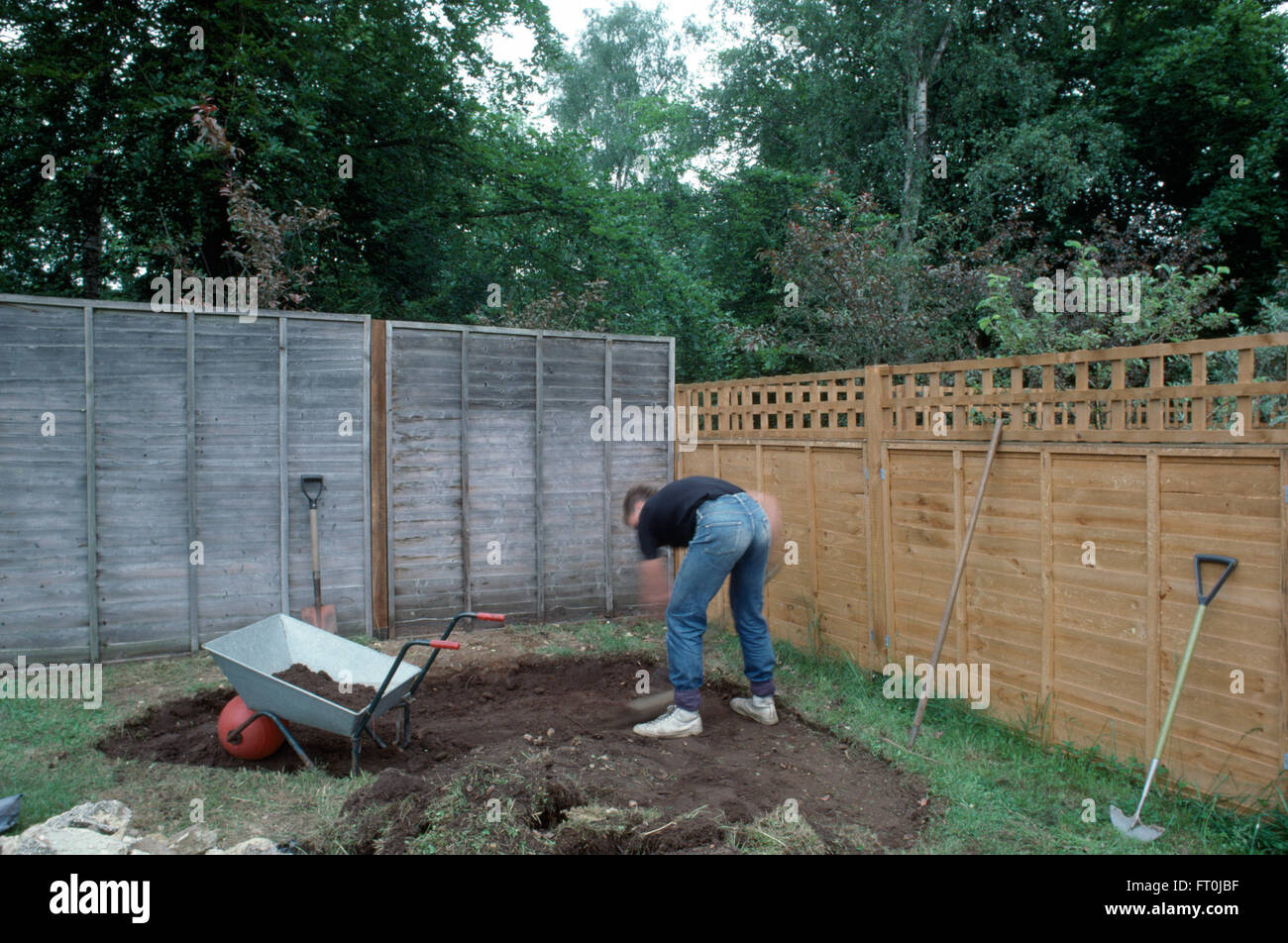 Gärtner ausgraben einer Fläche in einem Rasen zu einem neuen Steingarten für nur zur redaktionellen Nutzung Stockfoto