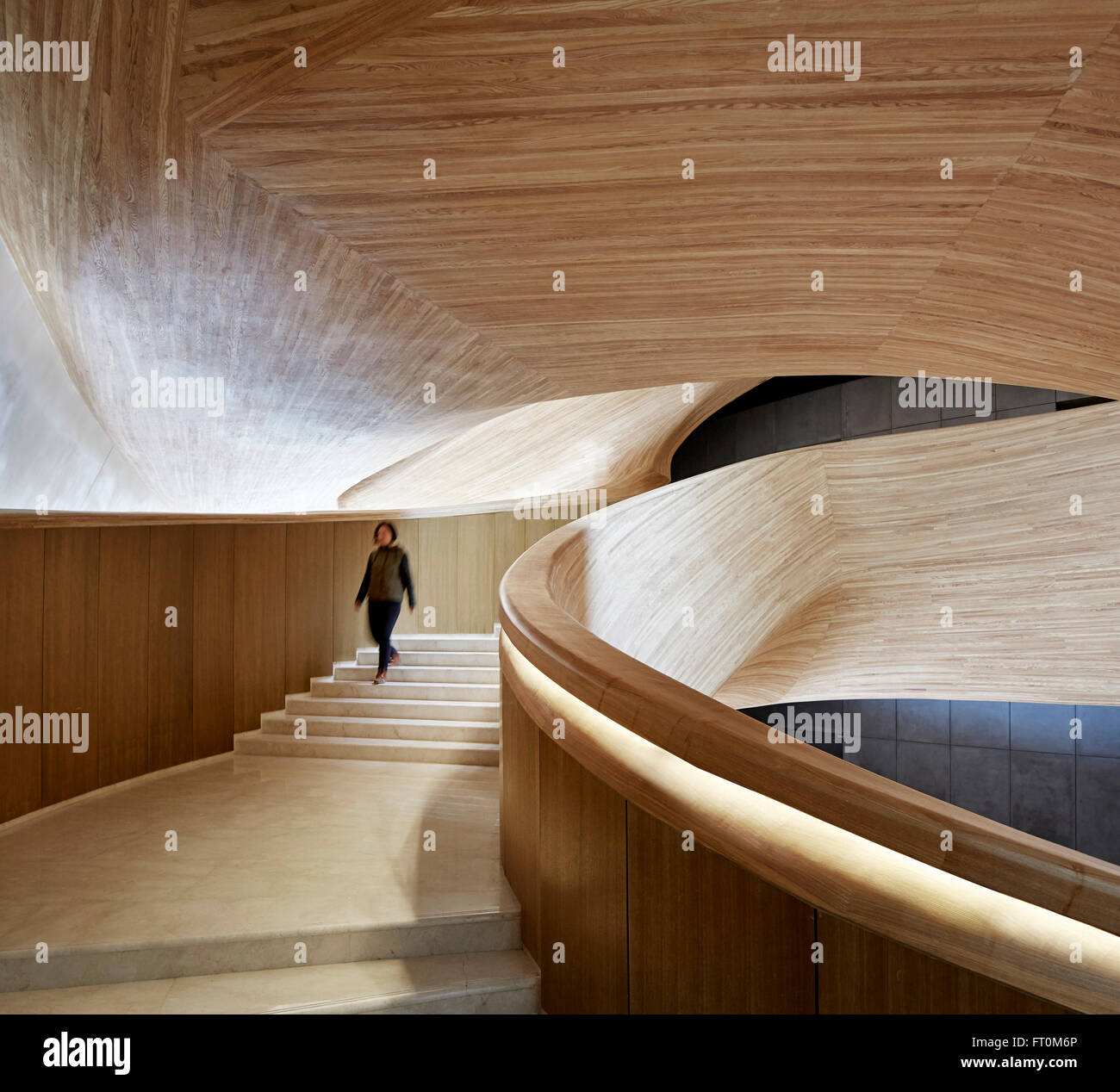 Gewundene Treppe in Holz verkleidet. Oper Harbin, Harbin, China. Architekt: Müller Architekten, 2015. Stockfoto