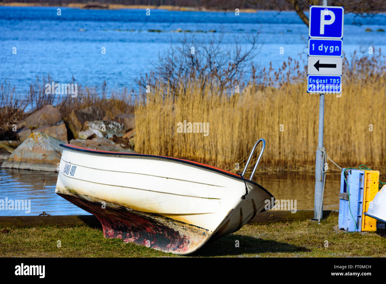 Torhamn, Schweden - 18. März 2016: Ein kleines Motorboot Außenborder parkte auf einem Parkplatz auf dem Land. Das Meer im Hintergrund. Stockfoto