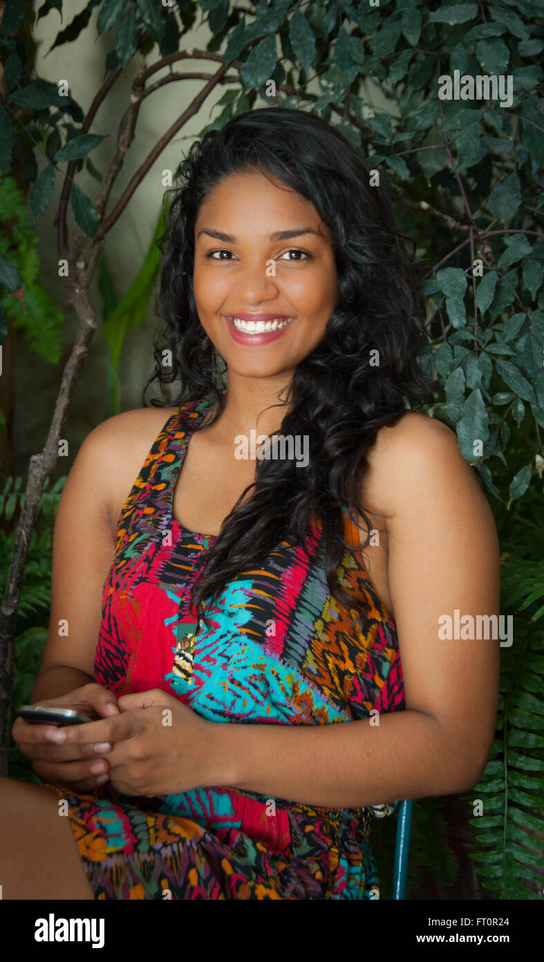 Lächelnde junge Hispanic Frau mit Handy auf Terrasse - Puerto Vallarta, Mexiko #613PV Stockfoto
