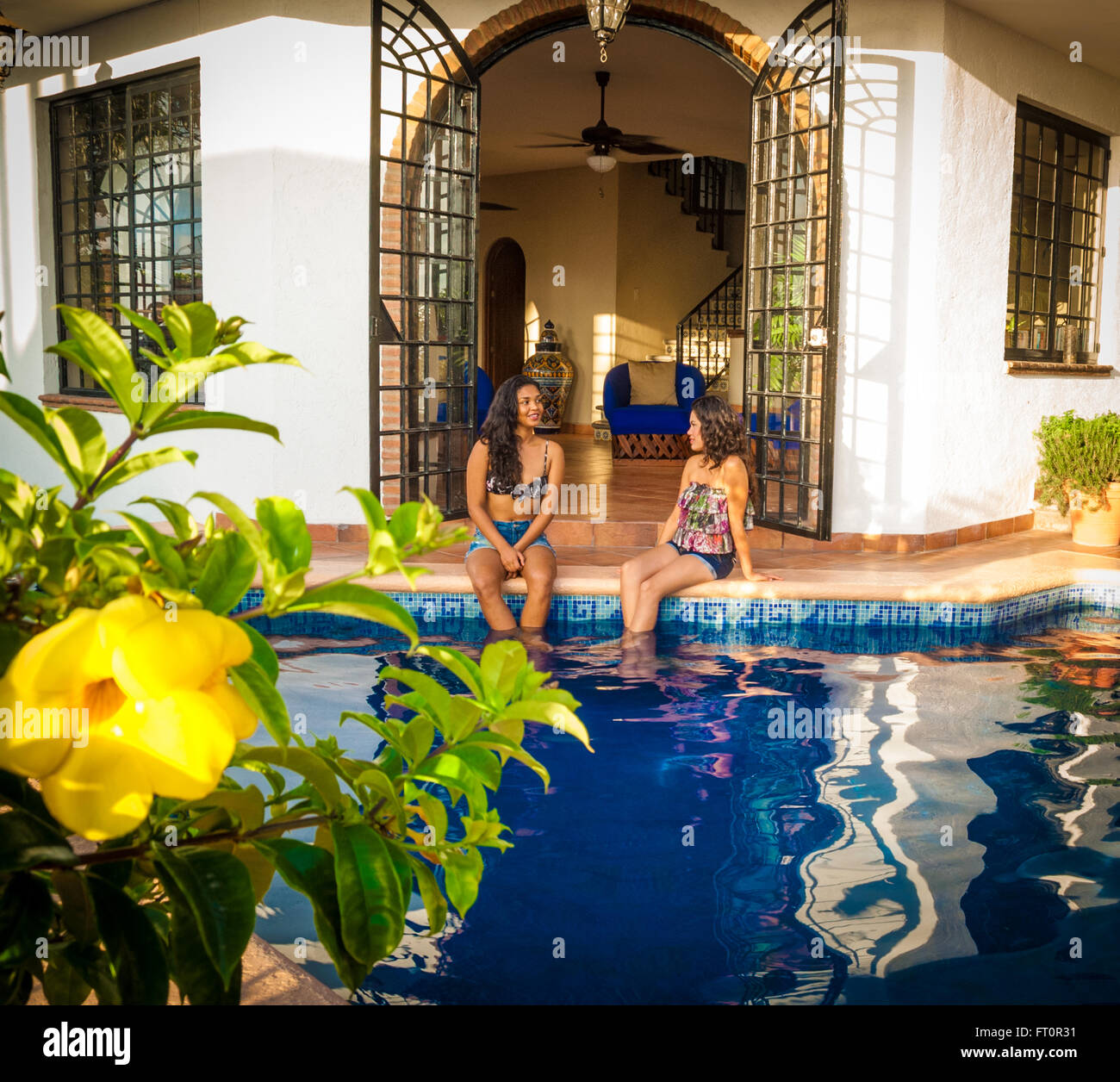 2 junge Hispanic Frauen sitzen, Swimming Pool, Puerto Vallarta, Mexiko #613PV Stockfoto