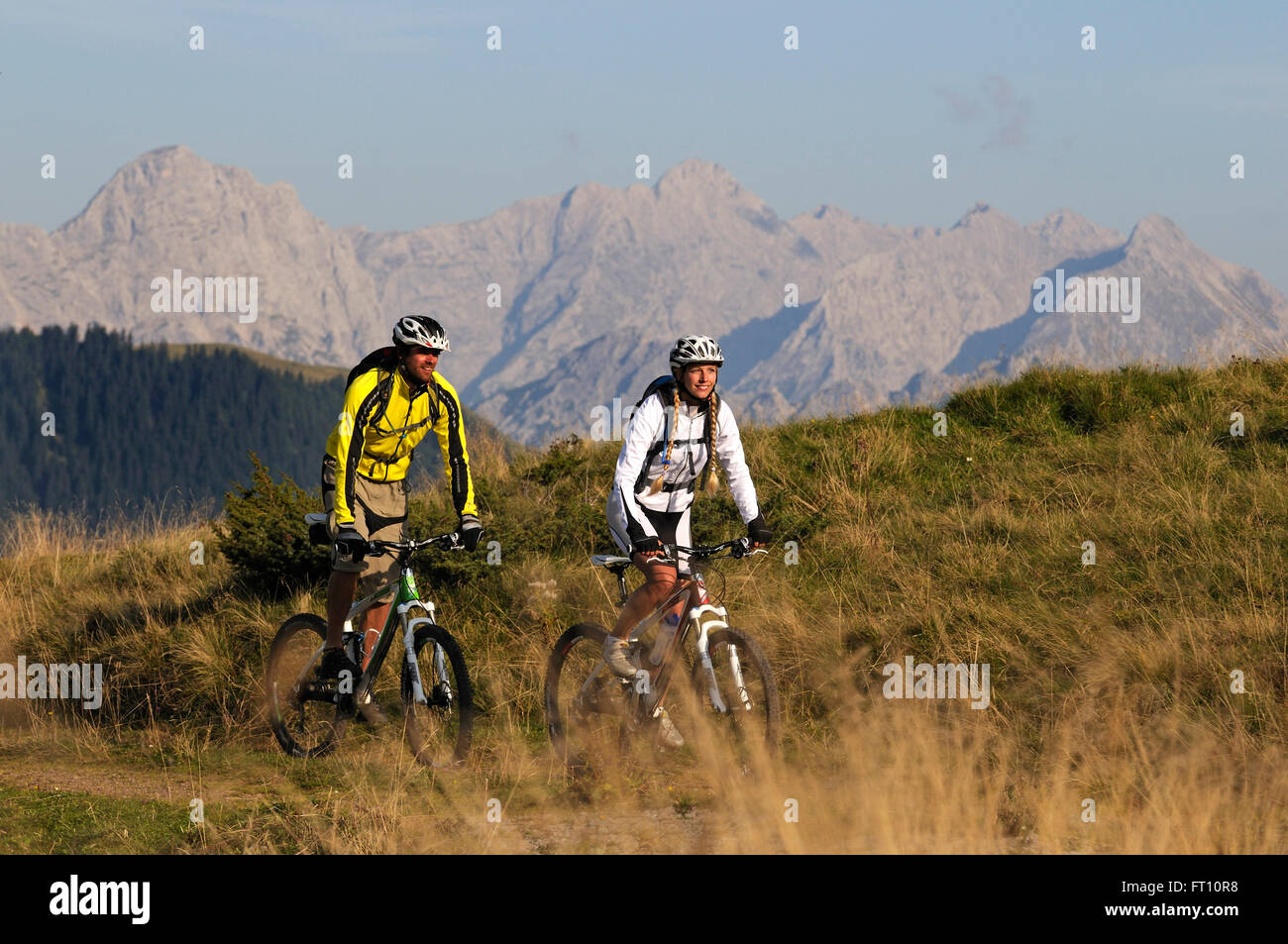 Mountainbiker vorbei Winklmoosalm, Berchtesgadener Alpen im Hintergrund, Chiemgau, Oberbayern, Deutschland Stockfoto
