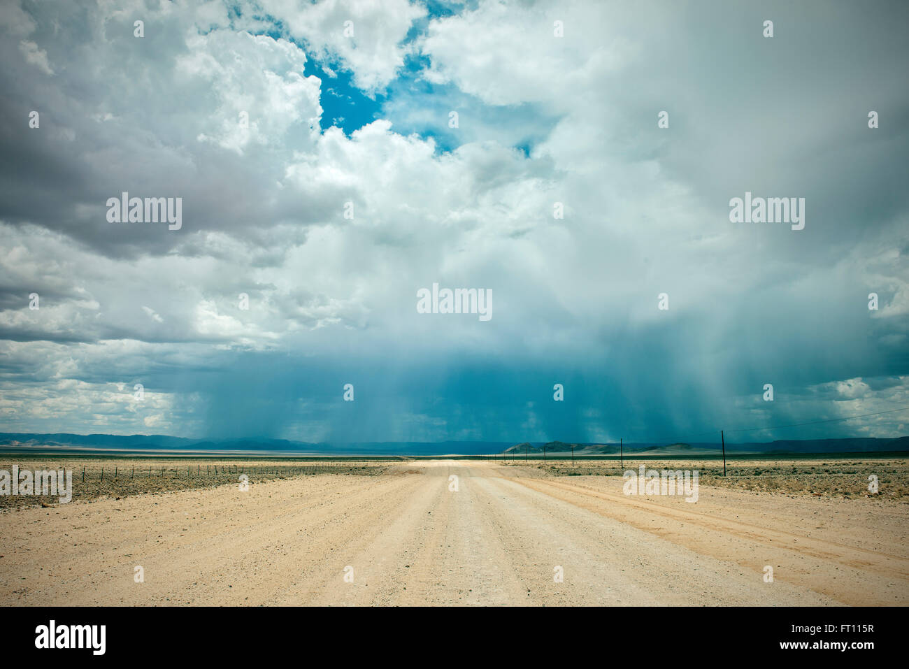 Staubige Straße mit Starkregen und Gewitter in der Ferne, Tiras Gebirge, Namib-Naukluft-Nationalpark, Namibia, Afrika Stockfoto