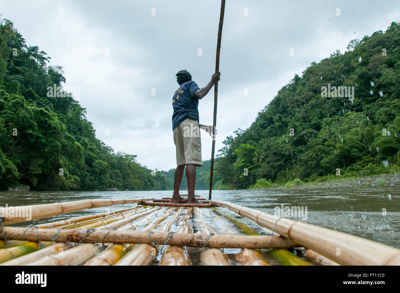 Mann Navigation traditionellen Bambus-Floß am Rio Grande River, Port Antonio, Portland, Jamaica Stockfoto