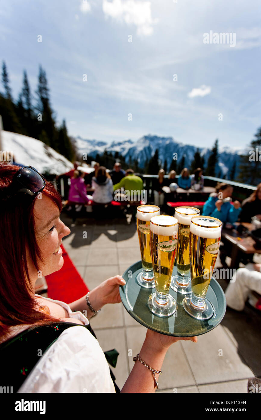 Kellnerin serviert Bier auf Skihütte Terrasse, Planai, Schladming, Steiermark, Österreich Stockfoto