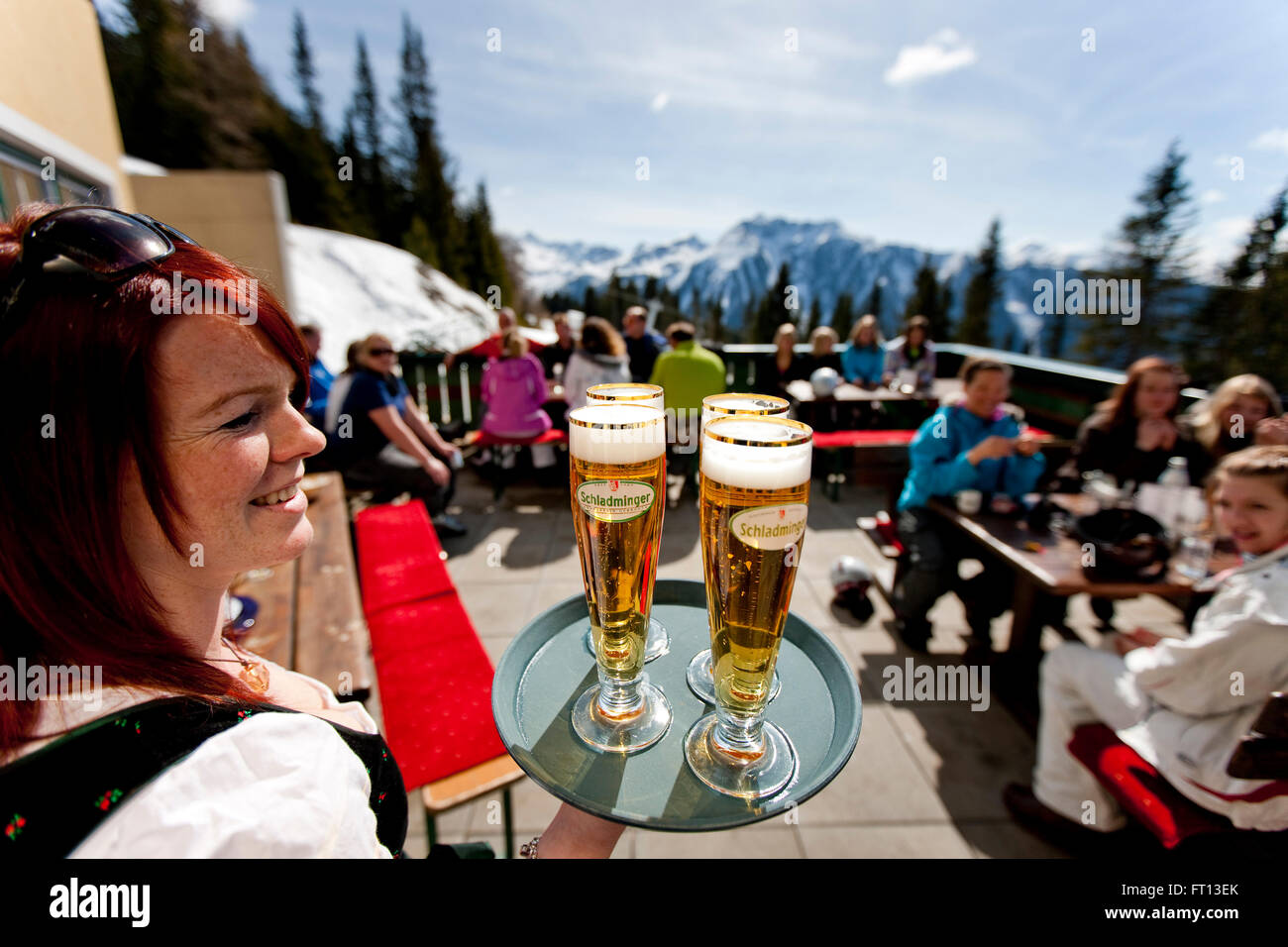 Kellnerin serviert Bier auf Skihütte Terrasse, Planai, Schladming, Steiermark, Österreich Stockfoto