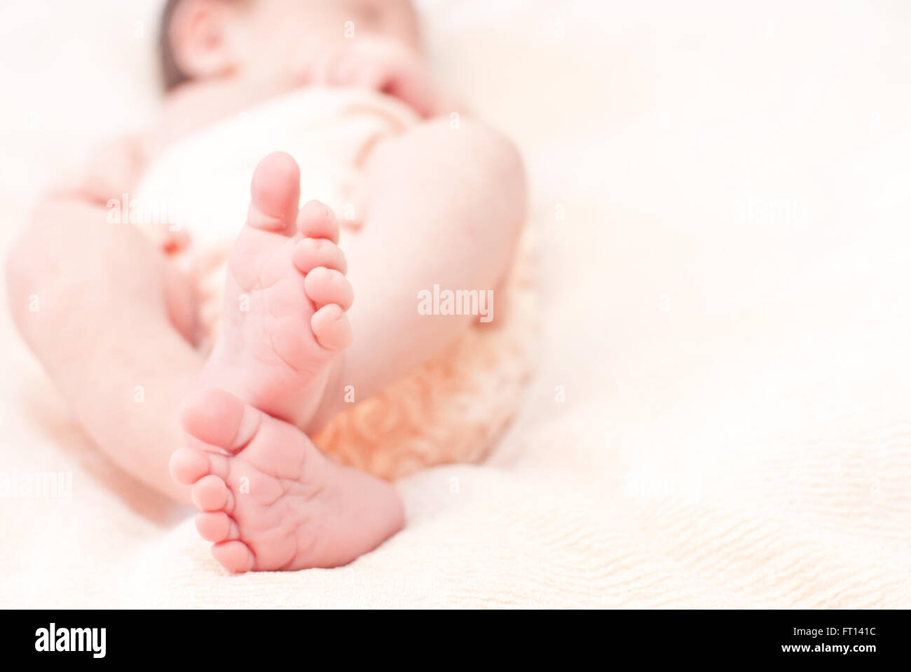 Nahaufnahme eines Babys Füße liegen auf einem weißen Blatt Stockfoto