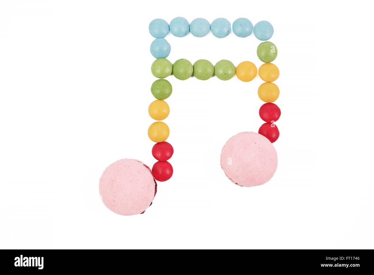 bunte Macaron Praline Musiknote auf weißem Hintergrund Stockfoto