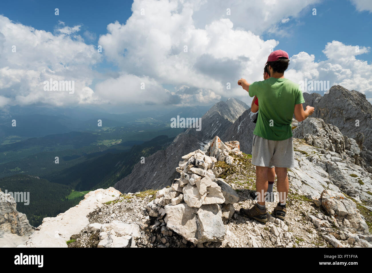 Wanderer, die von einem Berg mit Blick auf die Wälder und Almen in Ellmau Schloss in das Wetterstein-Gebirge, Bayern Stockfoto