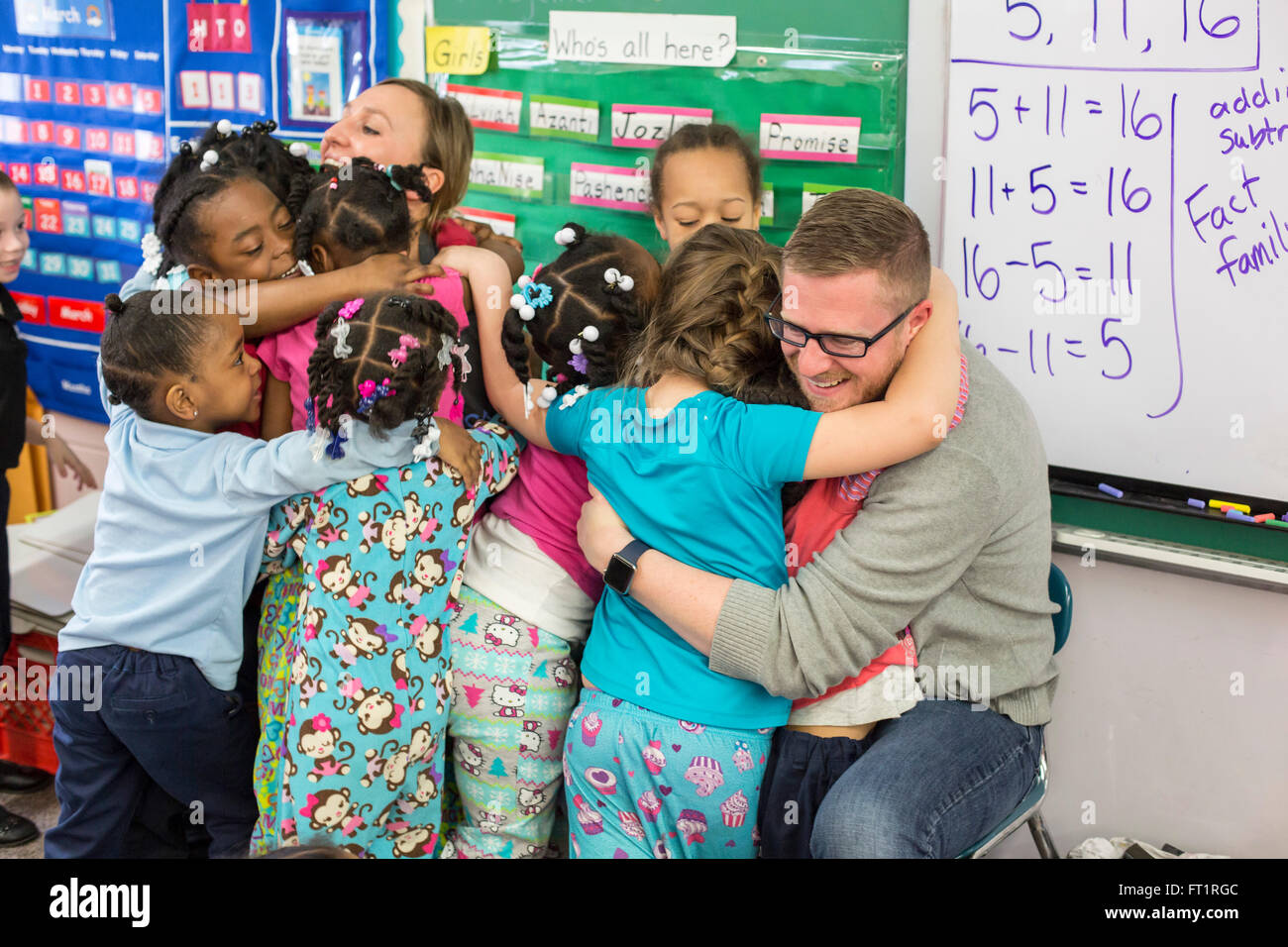 Pontiac, Michigan - Kindergarten Kinder umarmen Freiwilligen aus Fiat-Chrysler, die Bücher für sie gelesen haben. Stockfoto