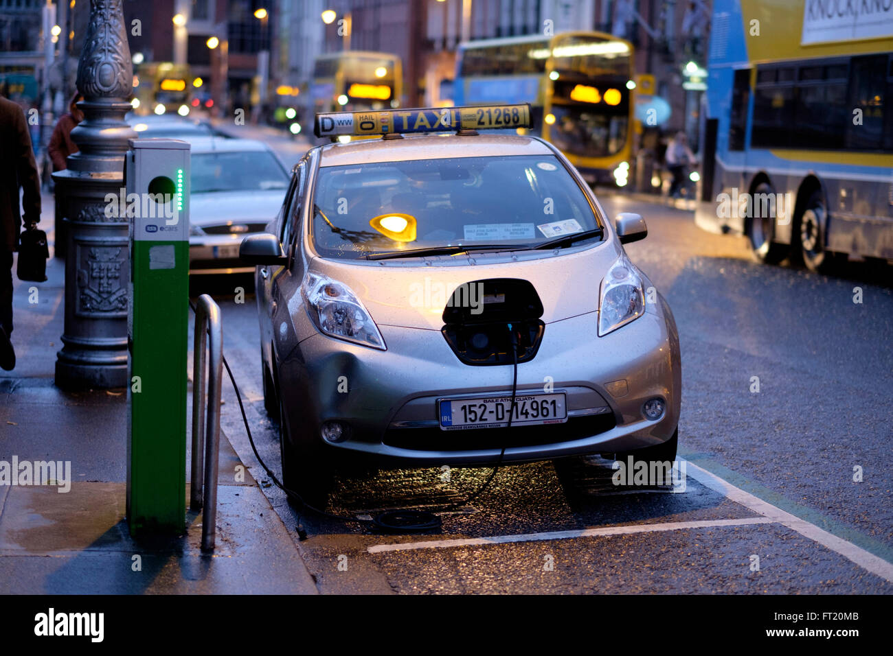 Elektro-Taxi Nissan Leaf Auto eingesteckt zum Aufladen an der Ladestation auf einer Straße in Dublin, Irland, Europa Stockfoto