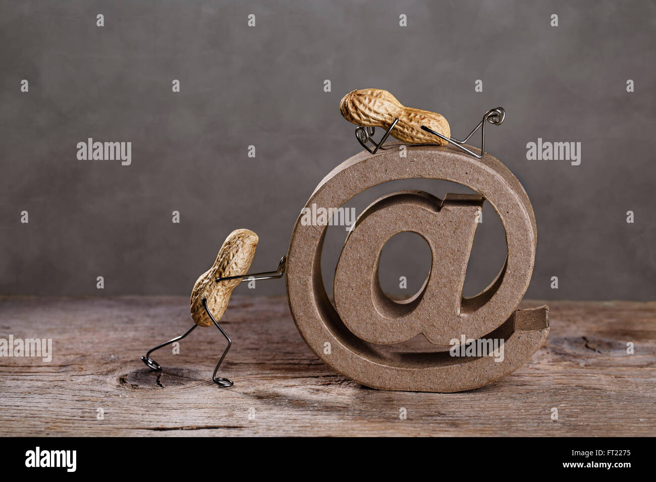 Erdnuss Menschen drängen ein großer AT-Zeichen als Symbol für das Internet und e-Mail Stockfoto