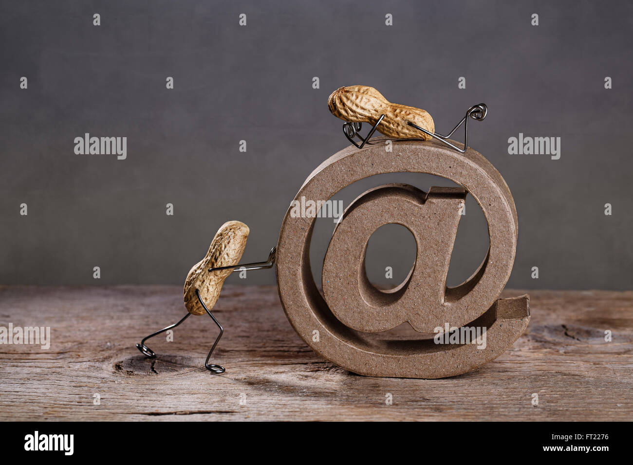 Erdnuss Menschen drängen ein großer AT-Zeichen als Symbol für das Internet und e-Mail Stockfoto