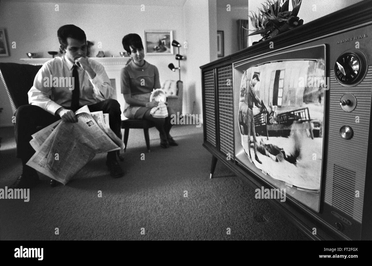 Vietnam-Krieg. Paar beobachten Filmmaterial des Vietnam-Krieges auf einem Fernseher in ihrem Wohnzimmer, Februar 1968 Stockfoto