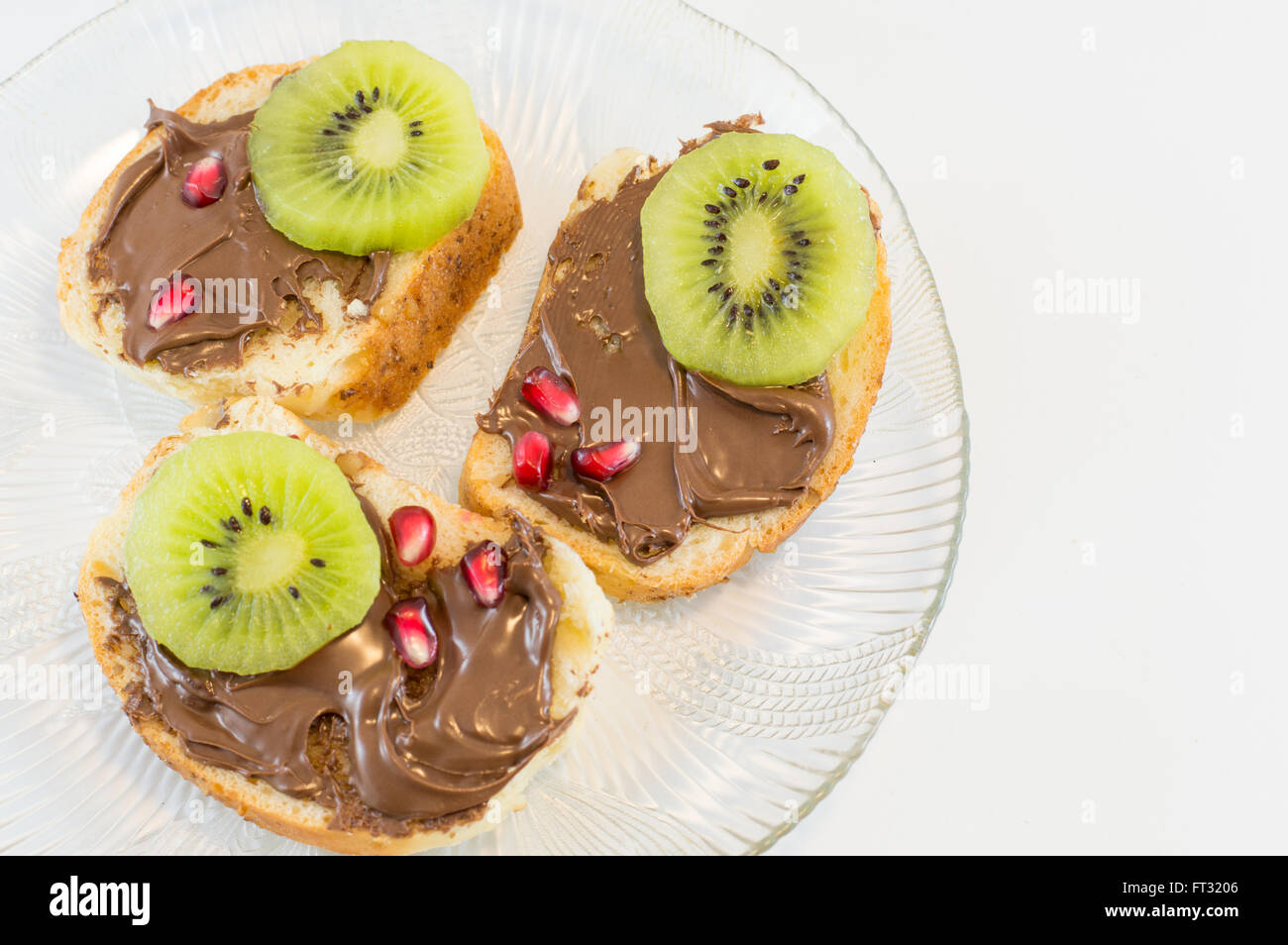 Schokoladencreme auf selbstgebackenes Brot mit Früchten an der Spitze Stockfoto