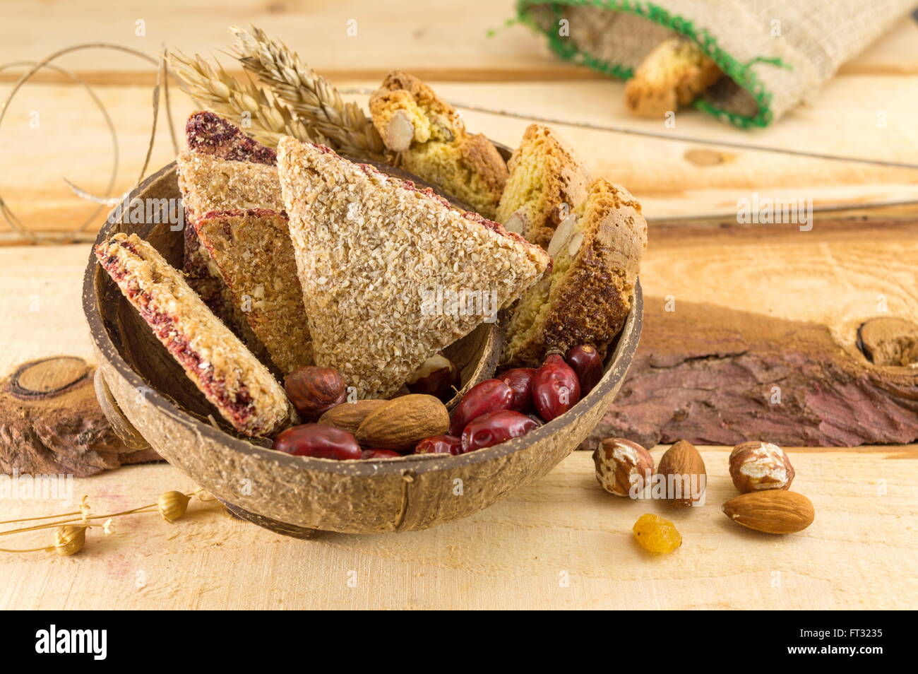 Integrale Kekse mit Mandeln und Hagebutten in einer Kokosnussschale serviert Stockfoto