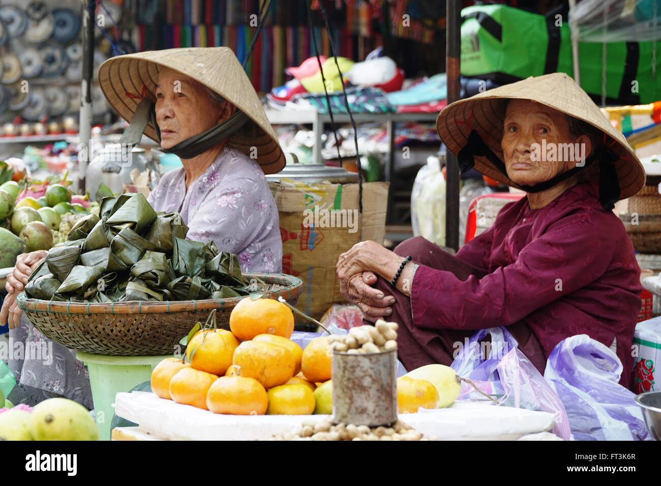 2 ältere vietnamesischen Frauen verkaufen Obst & Gemüse auf dem Markt in Hoi an, Vietnam. Stockfoto