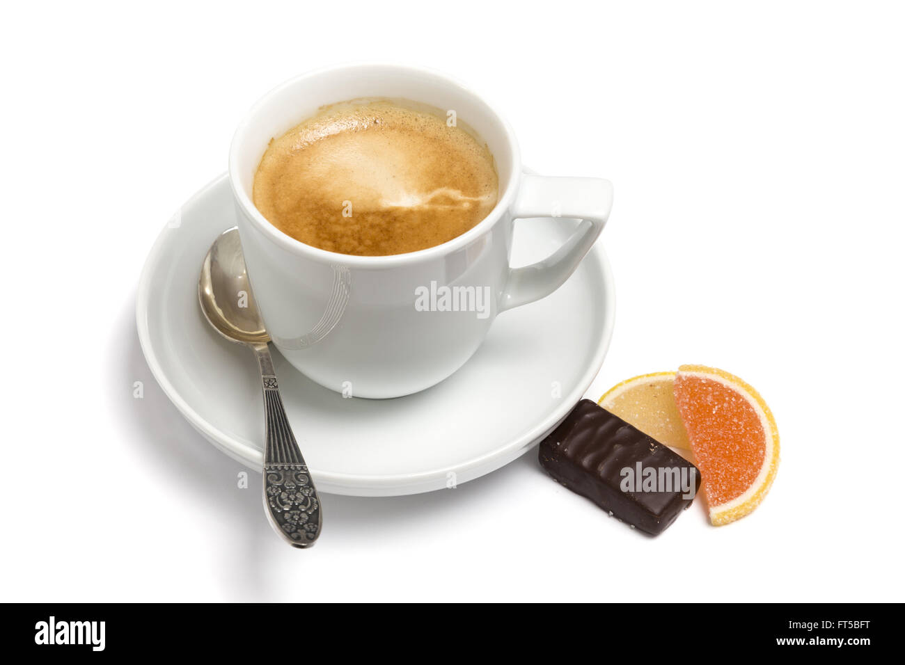 Eine Tasse Kaffee, kleine Löffel und Süßigkeiten auf eine Platte Nahaufnahme auf weißem Hintergrund Stockfoto