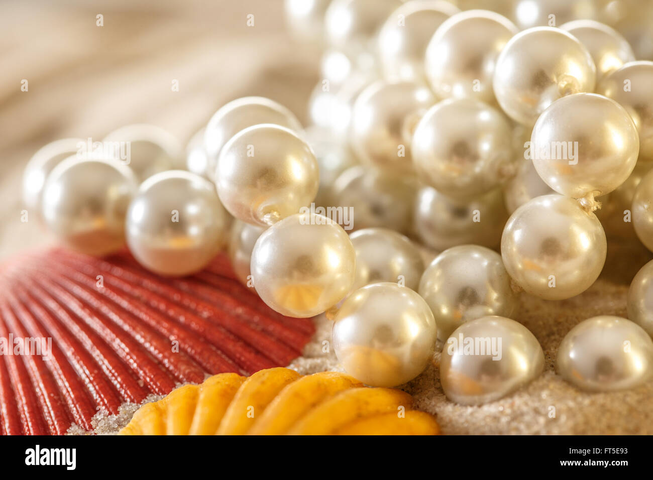 Weiße Perlen und Muscheln auf Sand Hintergrund Stockfoto