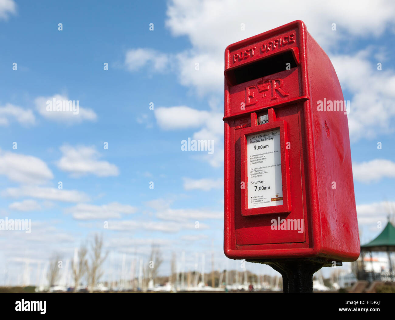 Einen roten Briefkasten vor einem blauen bewölkten Himmel abgebildet Stockfoto