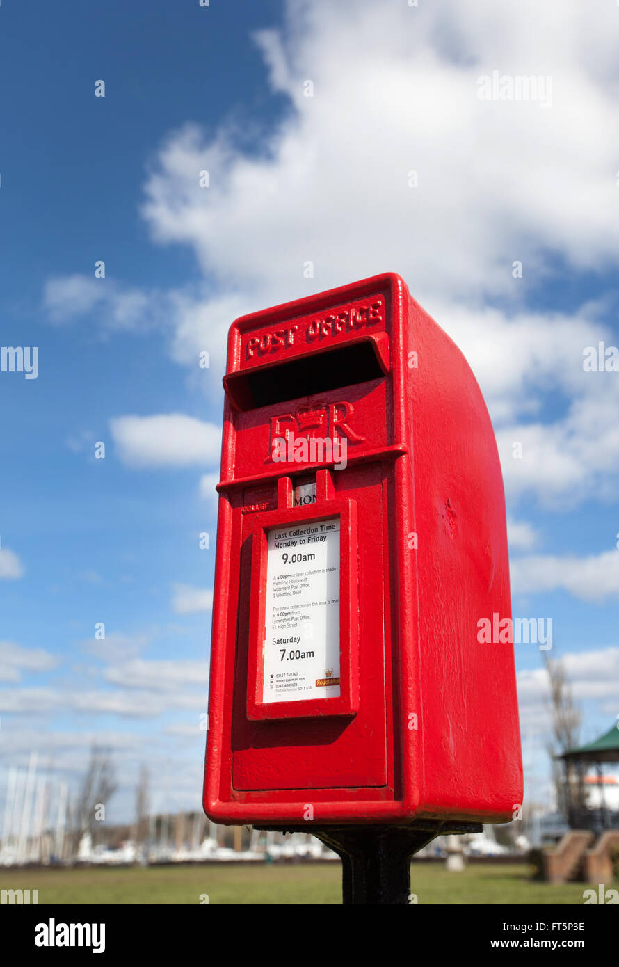 Einen roten Briefkasten vor einem blauen bewölkten Himmel abgebildet Stockfoto
