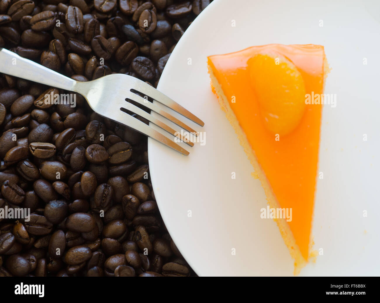 Orange Kuchen und gerösteten Kaffeebohnen Hintergrund Stockfoto