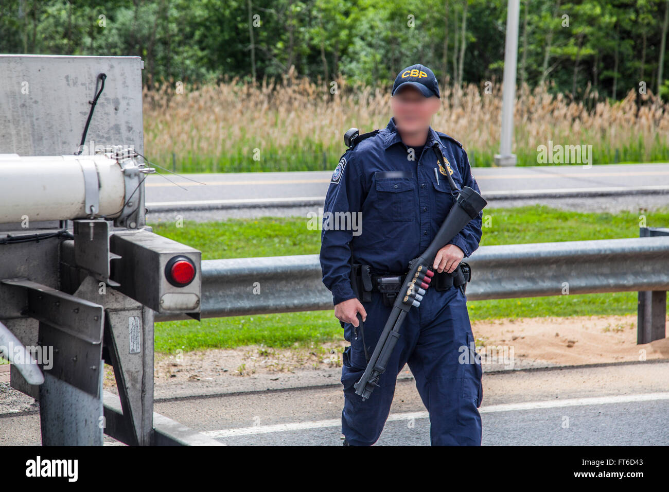 Am 15. Juni führt ein US-Zoll- und Grenzschutzbeamter eine gründliche Inspektion eines Traktoranhängers durch, was Teil der Suche nach den entflohenen Sträflingen Richard Matt und David Sweat ist. Diese Inspektion spiegelt die erhöhten Sicherheitsanstrengungen nach der Flucht wider. Stockfoto