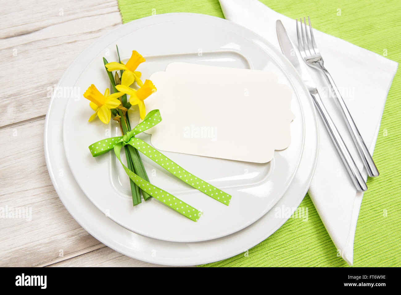 Frühling Zeit Tischdekoration mit Narzissen Blumen. Weißen Teller, Gabel, Messer Stockfoto