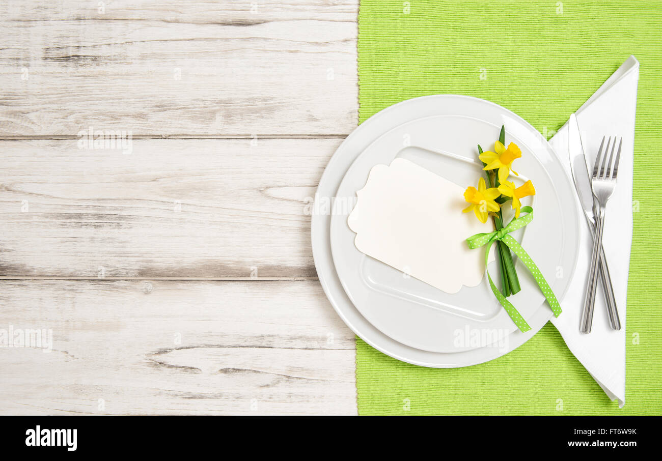 Frühling Tischdekoration mit Narzisse Blumen. Weißen Teller, Gabel, Messer Stockfoto