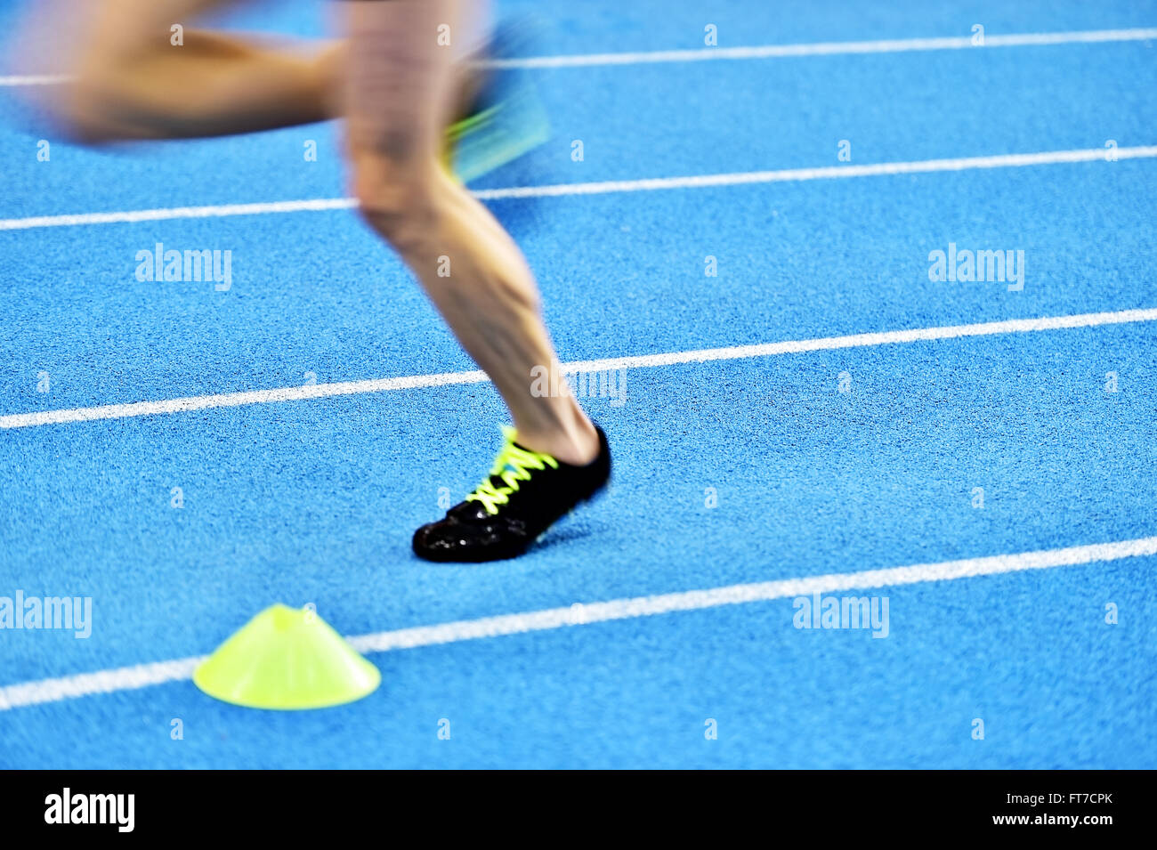 Verschwommene Athleten durch eine langsame Kamera Verschlusszeit auf blaue Sprint Track zu konkurrieren Stockfoto