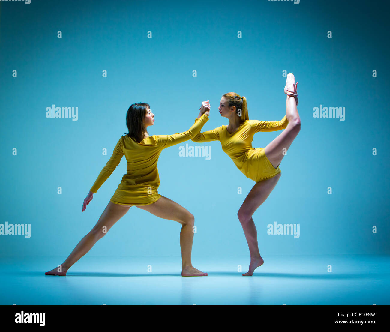 Die beiden modernen Balletttänzer tanzen auf grauem Hintergrund Stockfoto