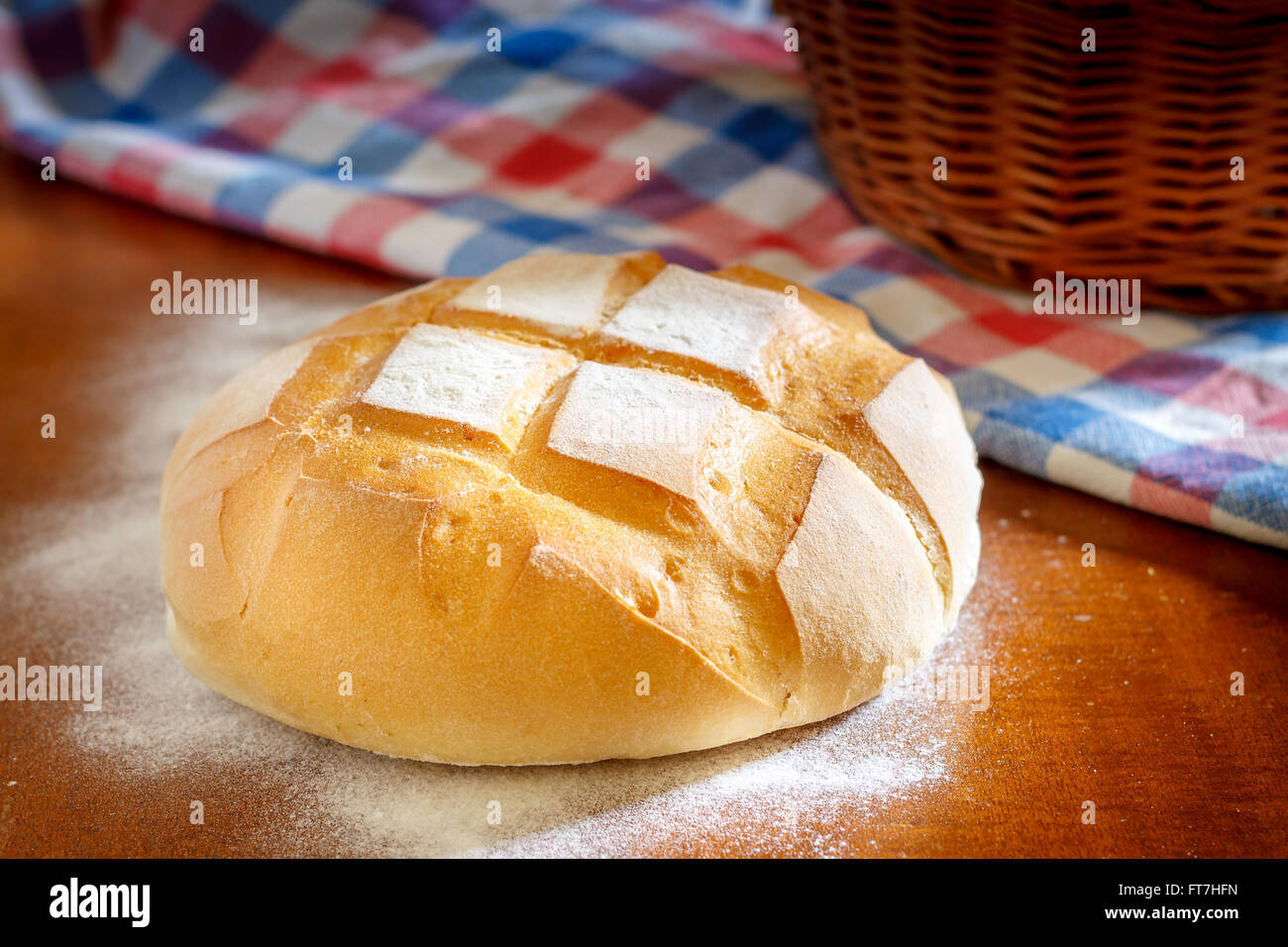 Runder Laib Brot mit Küche Lappen, Mehl und geflochtenen Korb Stockfoto